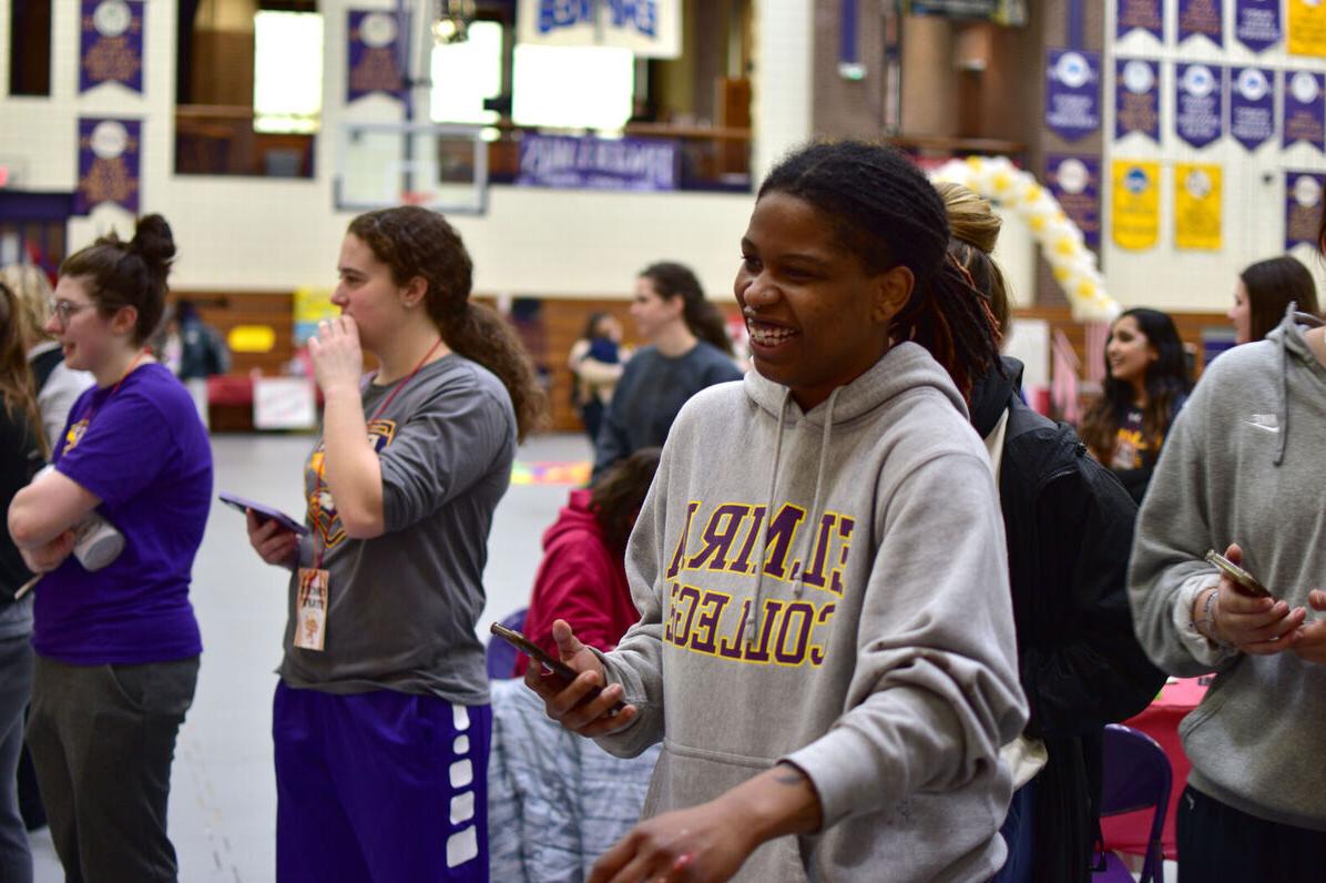 一名女学生在mg冰球突破豪华版下载大学舞蹈马拉松活动中大笑，周围的其他学生在一旁观看
